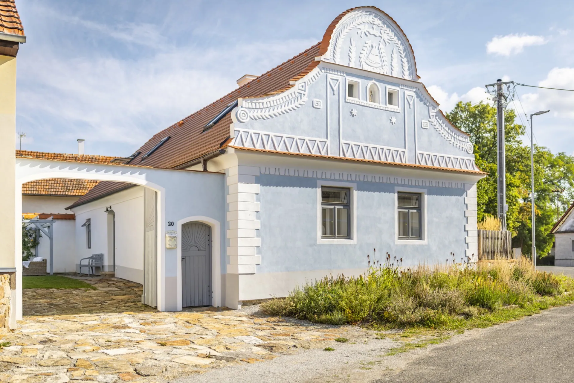 Usedlost Jamný s modrošedým zdobeným štítem a vjezdem do dvora