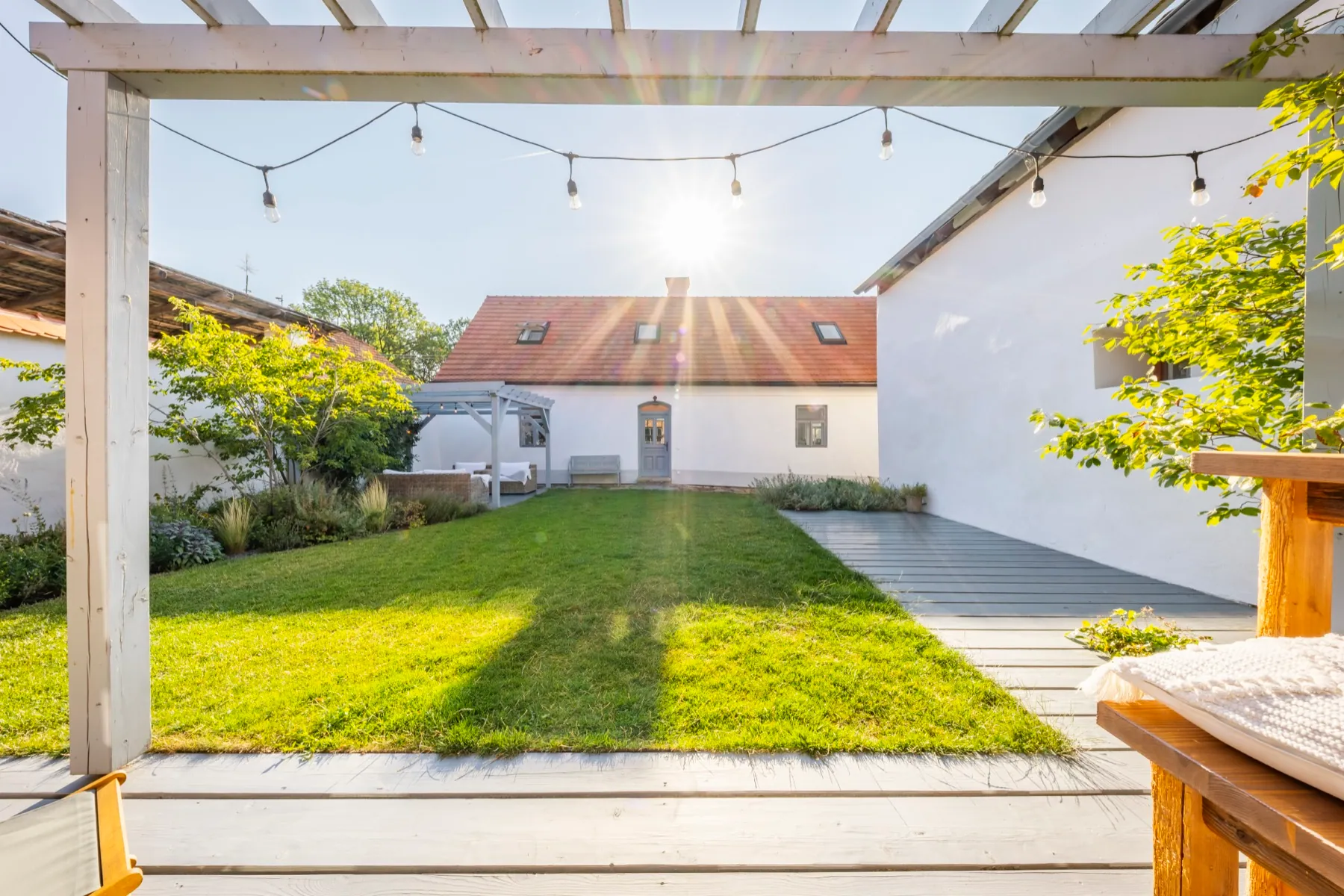 Pergola se světýlky a trávník v zahradě